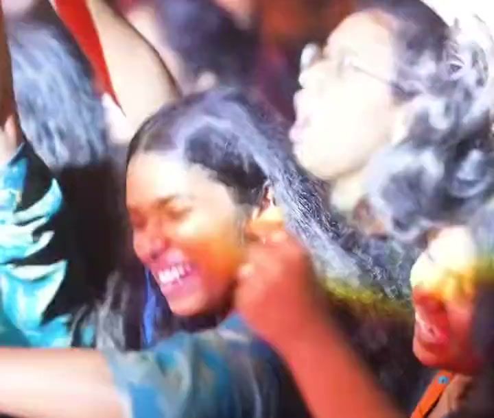 Students dancing in the crowd at KRazia ’26, with fireworks over the stage