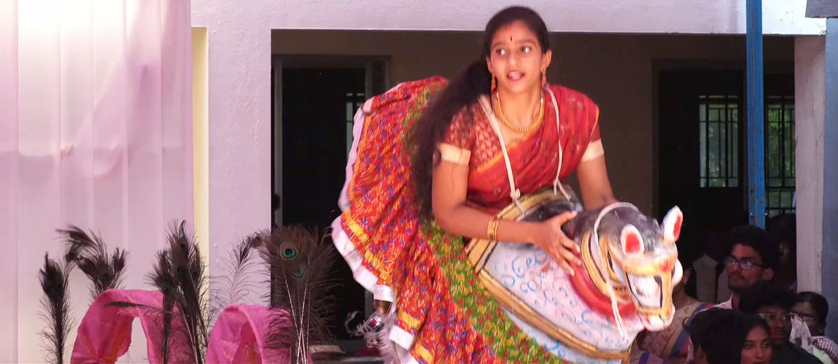 A student performing the poikkal kuthirai folk dance with a painted dummy horse